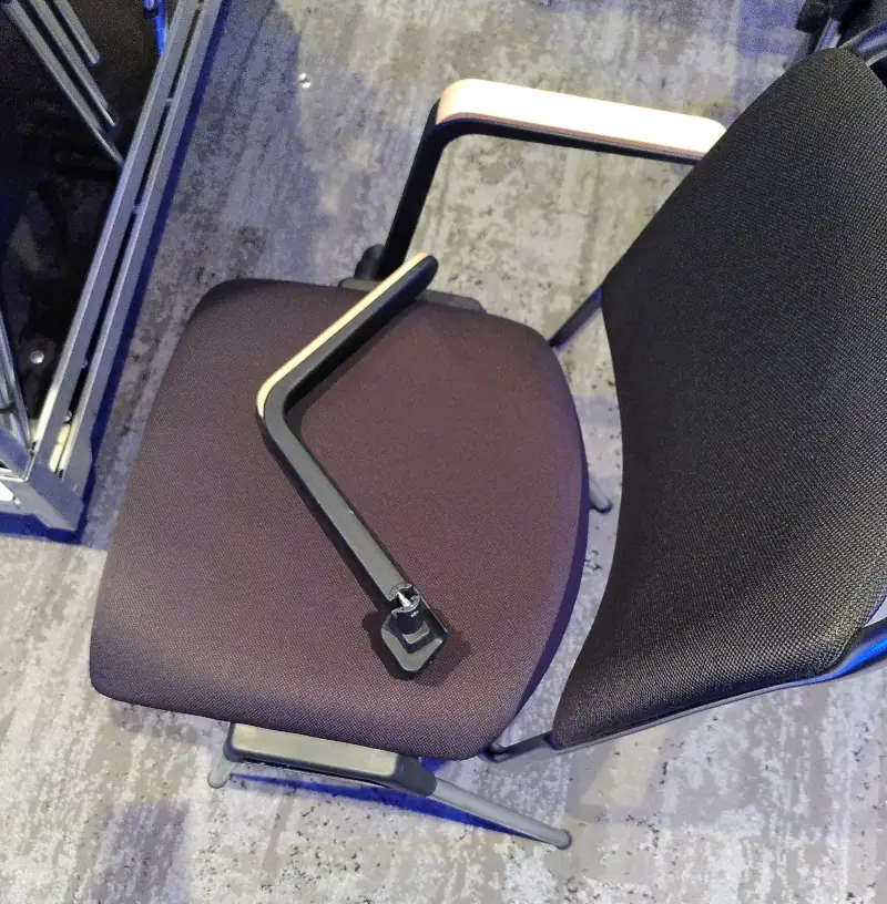 Ein Stuhl mit einer rechten Armlehne, aber ohne Linke Armlehne. Auf dem Stuhl liegt eine weitere rechte Armlehne.