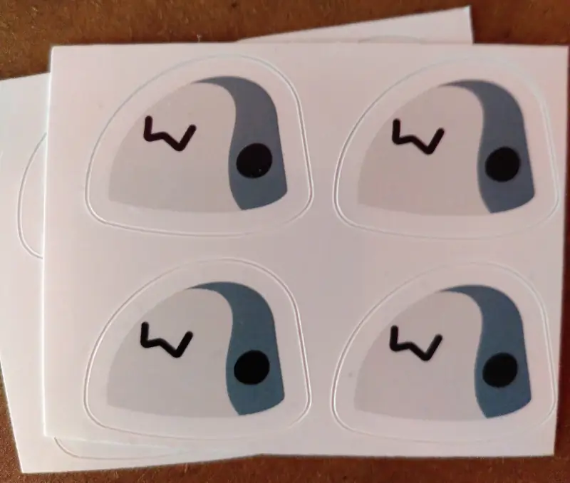 Ein Aufkleberbogen mit vier Blåhaj-Köpfen, die verschmitzt grinsen