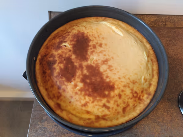 Ein Käsekuchen in einer Springform, von oben fotografiert.