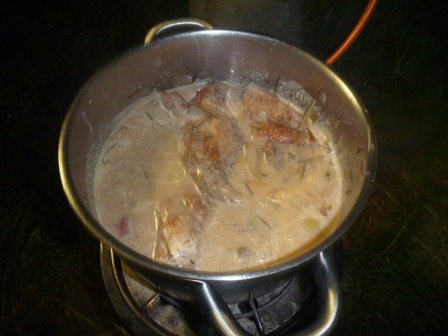 In trüber Brühe in einem Edelstahltop schwimmen einige große Stücke Fleisch am Knochen.