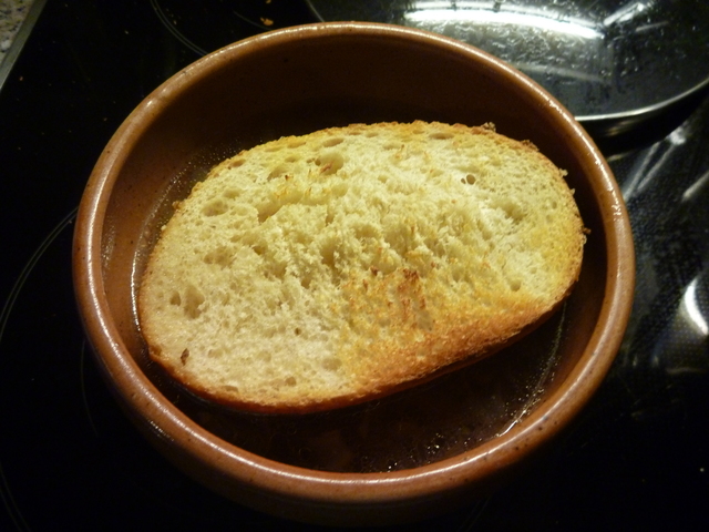 getoastetes Brötchen auf Zwiebelsuppe in einem Schälchen