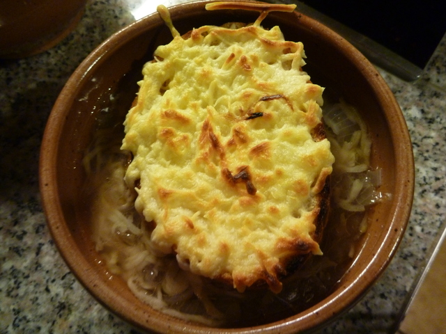 mit Käse überbackenes Brötchen auf der Zwiebelsuppe