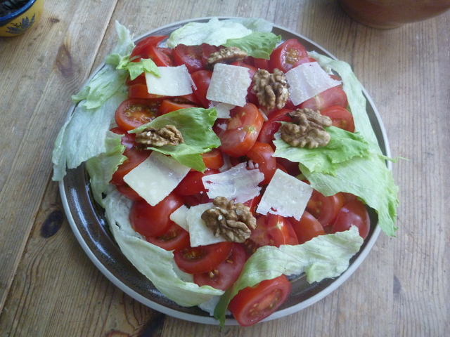 Die Tomaten auf Roquefortcrème sind mit Walnüssen, Parmesanscheibchen und Eisbergsalat verziert