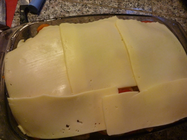 Käse über einer gefüllten Auflaufform