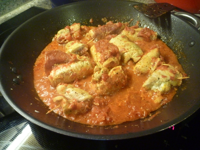 bratende Putenröllchen in Tomatensoße in der Pfanne