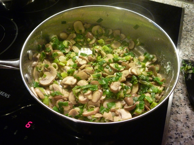 Angeröstete Lauchzwiebeln und Champignons im Topf