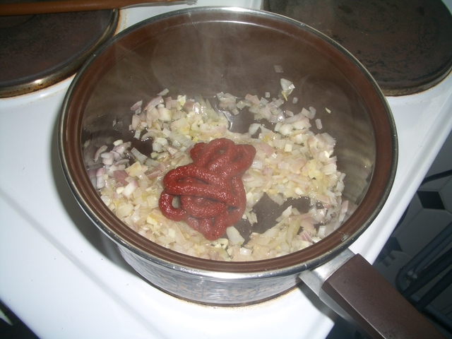 Bild von Zwiebeln in Öl in einem Topf mit Tomatenmark