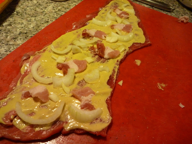 Rindfleischscheiben mit Zwiebeln und Speck belegt